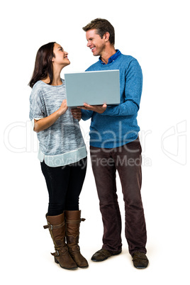 Smiling couple using laptop