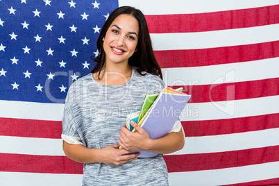 Portrait of smiling woman standing against American flag