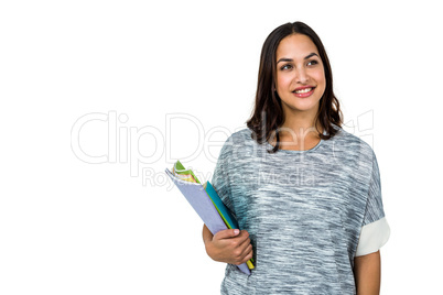 Woman holding books while looking away