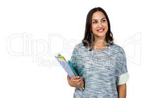 Woman holding books while looking away