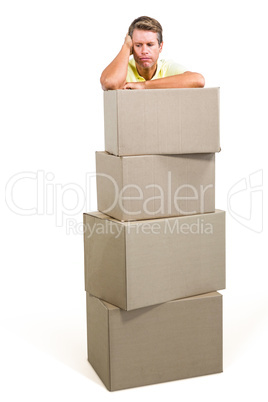 Man thinking while standing with boxes