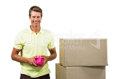 Happy man holding pink piggy bank