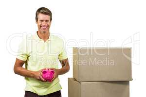Happy man holding pink piggy bank