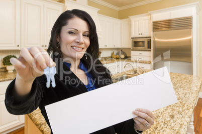 Hispanic Woman In Kitchen Holding House Keys and Blank Sign