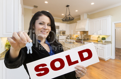 Hispanic Woman In Kitchen Holding House Keys and Sold Sign