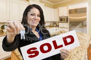 Hispanic Woman In Kitchen Holding House Keys and Sold Sign