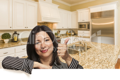 Hispanic Woman with Thumbs Up In Custom Kitchen Interior