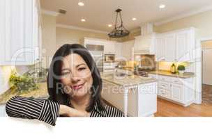 Hispanic Woman Leaning Against White In Custom Kitchen Interior