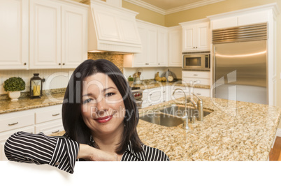 Hispanic Woman Leaning Against White In Custom Kitchen Interior