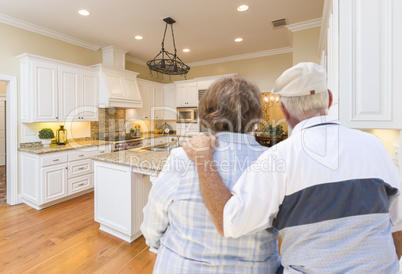 Senior Couple Looking Over Beautiful Custom Kitchen