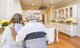Senior Couple Looking Over Beautiful Custom Kitchen