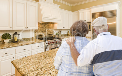 Senior Couple Looking Over Beautiful Custom Kitchen