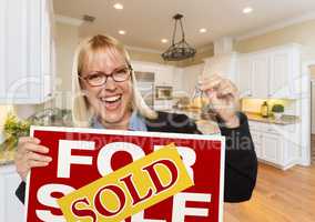 Young Woman Holding Sold Sign and Keys Inside New Kitchen