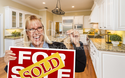 Young Woman Holding Sold Sign and Keys Inside New Kitchen