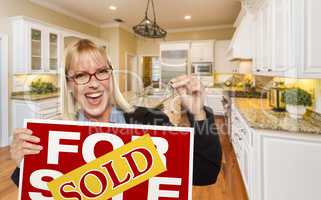 Young Woman Holding Sold Sign and Keys Inside New Kitchen