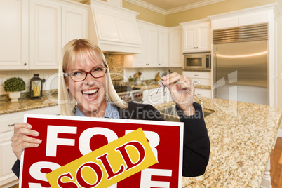 Young Woman Holding Sold Sign and Keys Inside New Kitchen