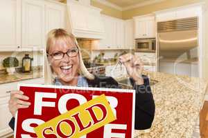 Young Woman Holding Sold Sign and Keys Inside New Kitchen