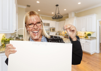 Young Woman Holding Blank Sign and Keys Inside Kitchen