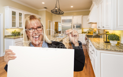 Young Woman Holding Blank Sign and Keys Inside Kitchen