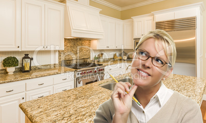 Daydreaming Woman with Pencil Inside Beautiful Custom Kitchen