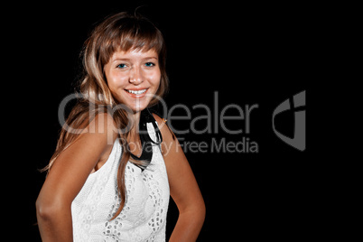 Smiling blue-eyed blonde girl in white dress on black background