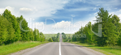 highway among green fields and blue sky
