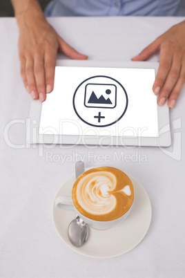 Composite image of close-up of digital tablet and coffee on tabl