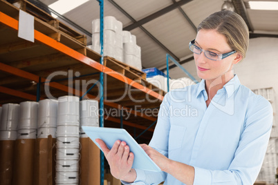 Composite image of businesswoman using tablet pc