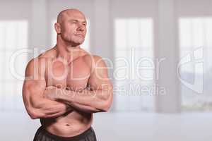 Composite image of muscular fit man with arms crossed