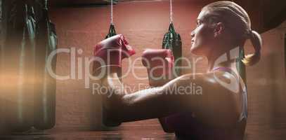 Composite image of side view of female boxer with fighting stance