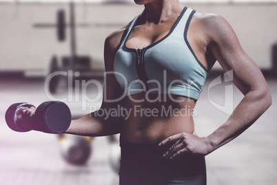 Composite image of midsection of woman lifting dumbbell