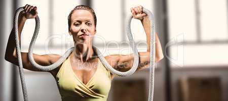 Composite image of healthy woman holding rope around neck with a