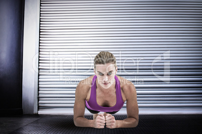 Composite image of muscular woman doing push ups