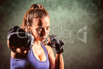 Composite image of portrait of female fighter punching