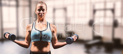 Composite image of portrait of confident man holding dumbbells