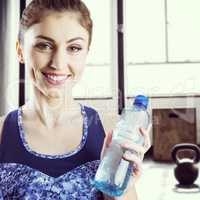 Composite image of fit brunette holding water bottle