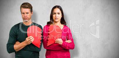 Composite image of portrait of serious couple holding cracked he