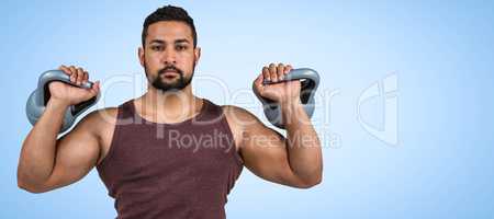 Composite image of muscular serious man lifting kettlebells