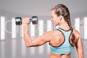 Composite image of rear view of woman lifting dumbbell