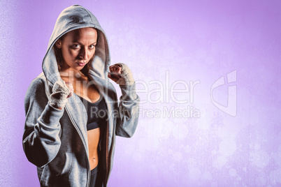 Composite image of portrait of female boxer in hood with fightin