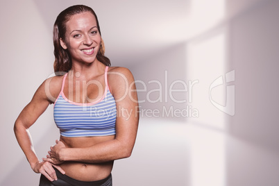 Composite image of portrait of smiling athlete with hands on hip