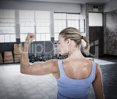 Composite image of rear view of muscular woman flexing muscles