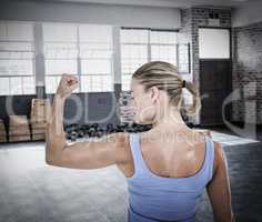 Composite image of rear view of muscular woman flexing muscles