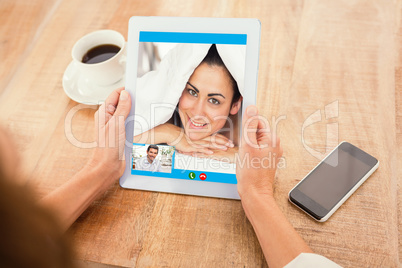 Composite image of smiling man using digital tablet at home
