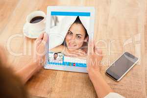 Composite image of smiling man using digital tablet at home