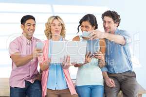 Composite image of casual businesspeople using digital tablet wi