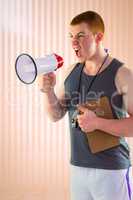 Composite image of angry personal trainer yelling through megaph