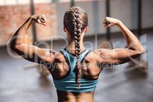 Composite image of rear view of woman with braided hair flexing