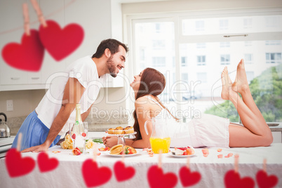 Composite image of young couple having a romantic breakfast