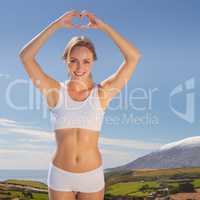 Composite image of gorgeous fit blonde making heart shape with h